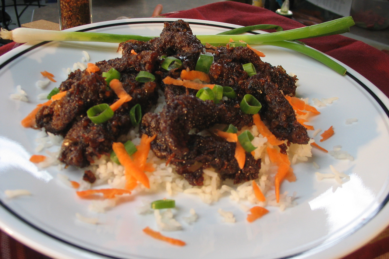 Stir fried ginger beef on carrots and rice