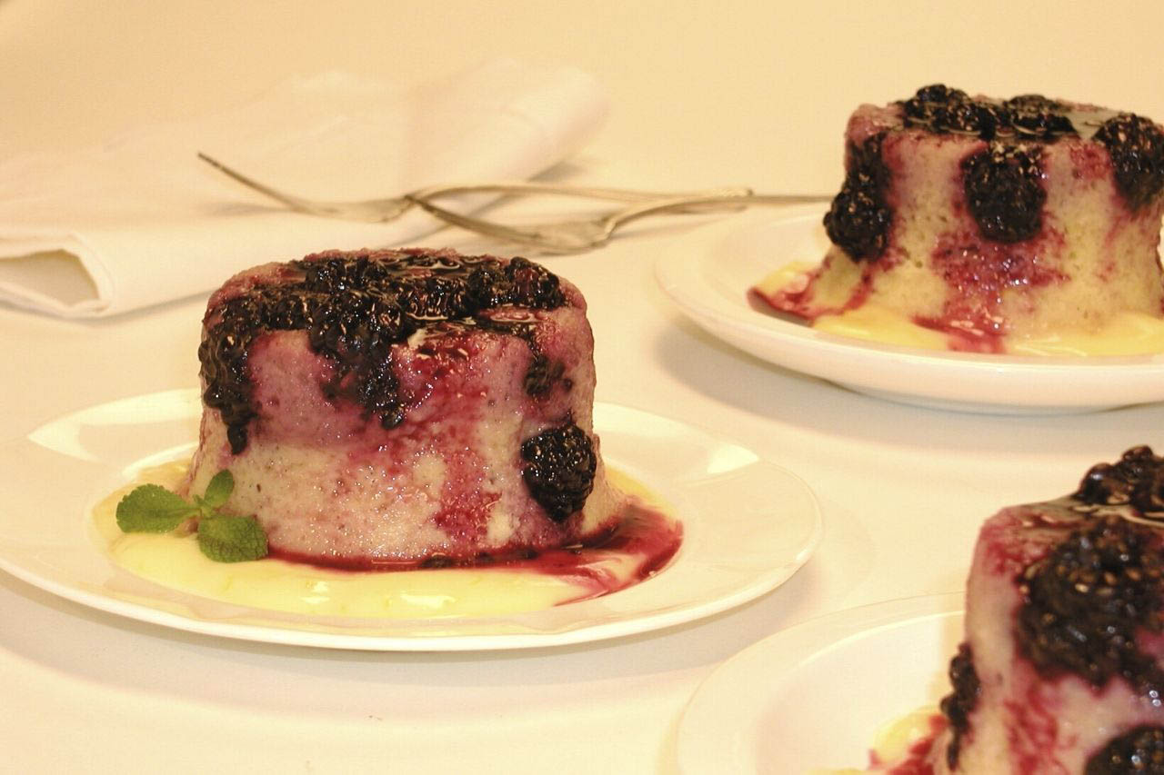 Three plates of Anna Olson's steamed blueberry pudding