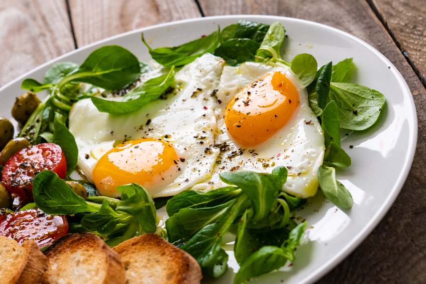 Breakfast - toasts, fried egg and vegetables - stock photo