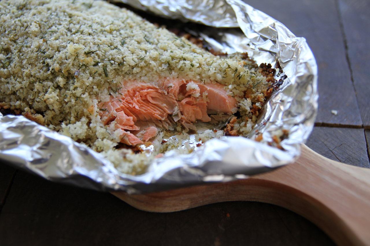 Salmon in an aluminum foil canoe and topped with a horseradish and herb topping