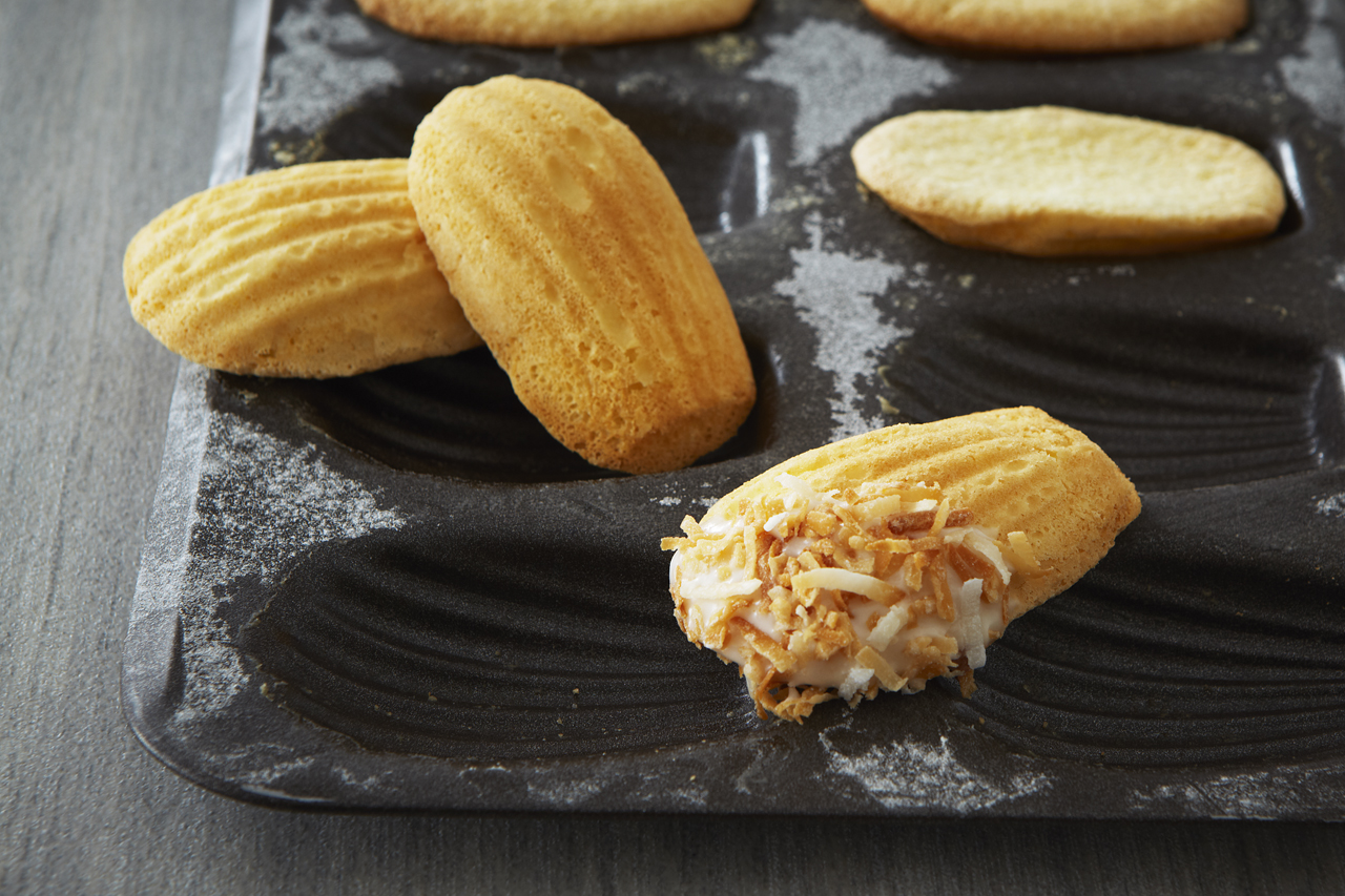 Madeleines iced and topped with toasted coconut flakes