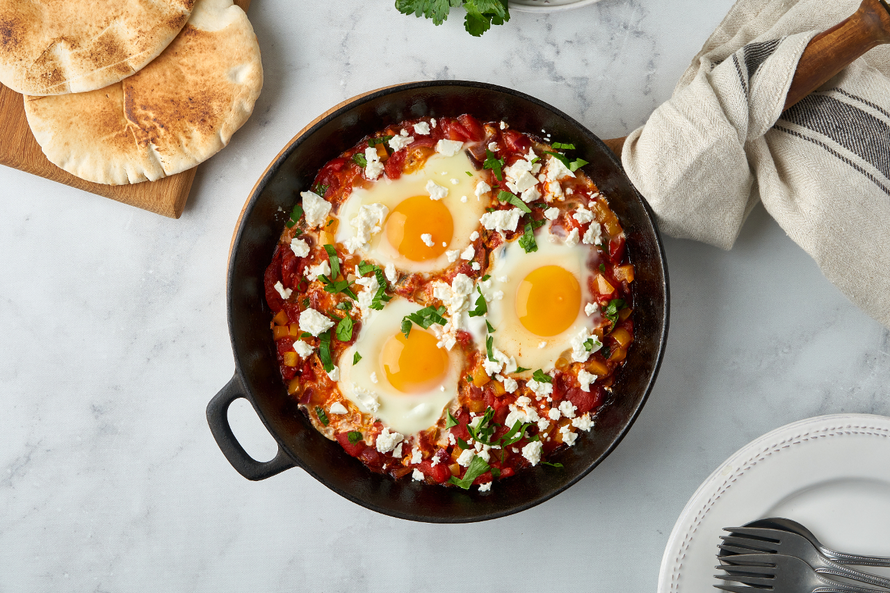 Shakshouka, eggs poached in sauce of tomatoes, olive oil, peppers, onion and garlic, Mediterranean cuisine. Keto meal, FODMAP recipe, low carb. Top view, vertical - stock photo