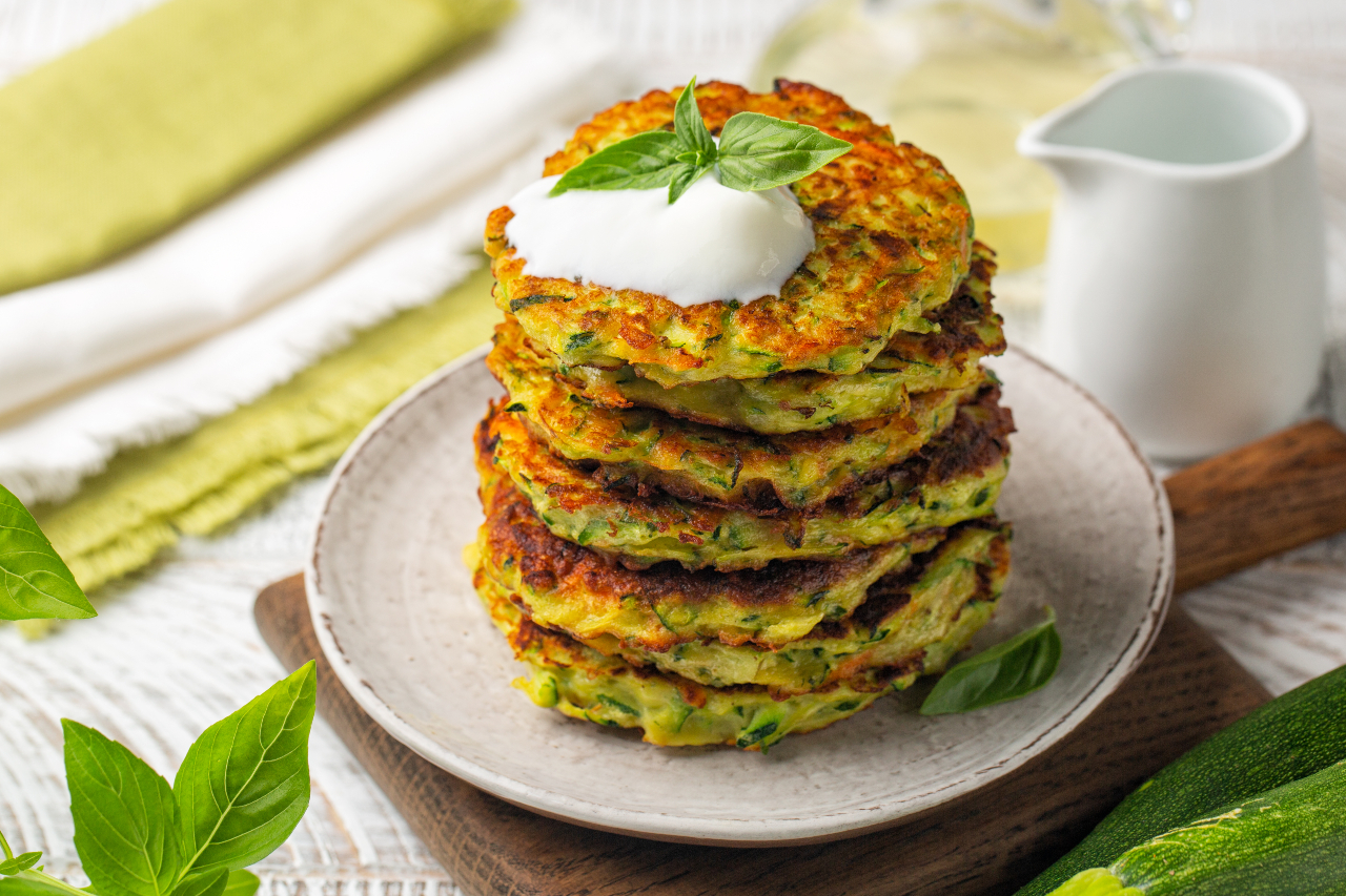 Zucchini fritters served with basil and greek yogurt. Summer meal. - stock photo