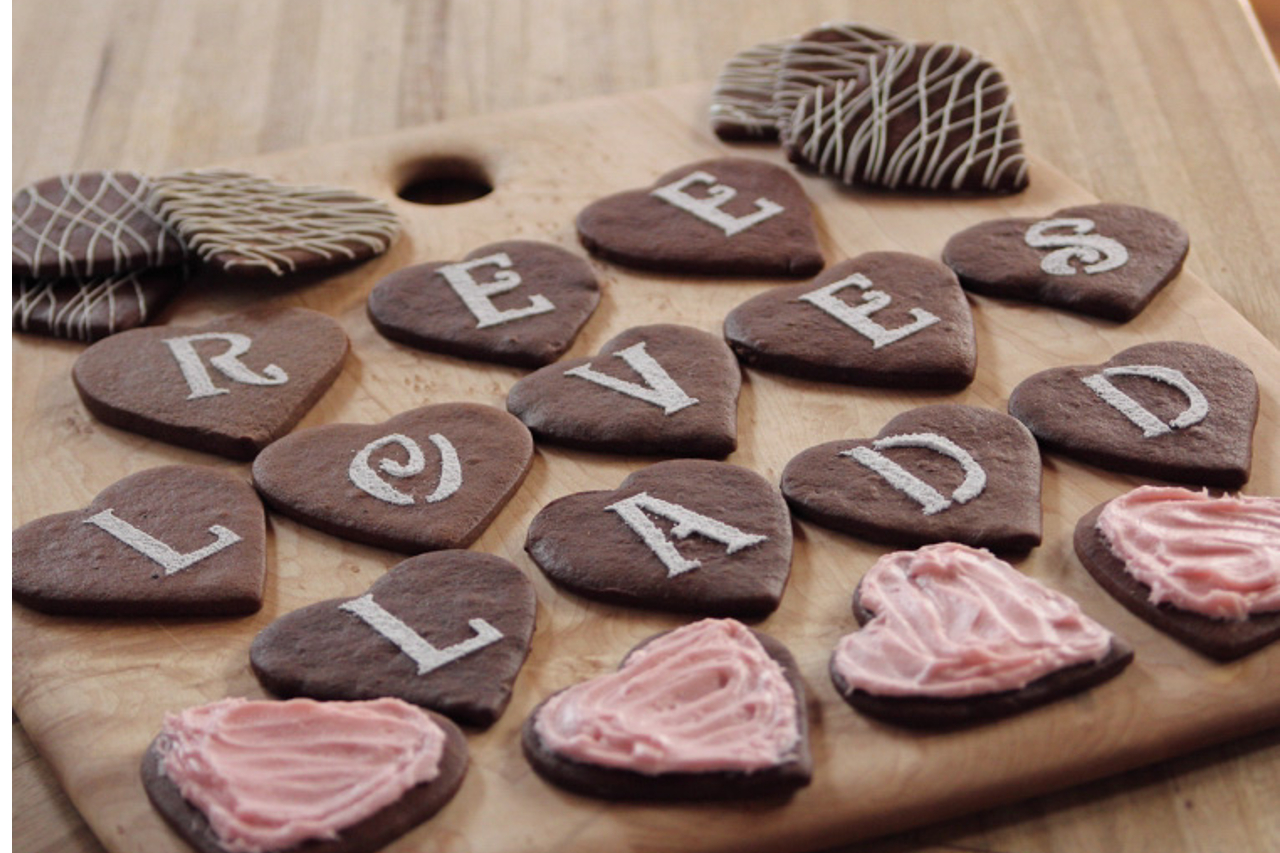 Chocolate cookies on a wooden board that spell out, "Ree loves Lad"