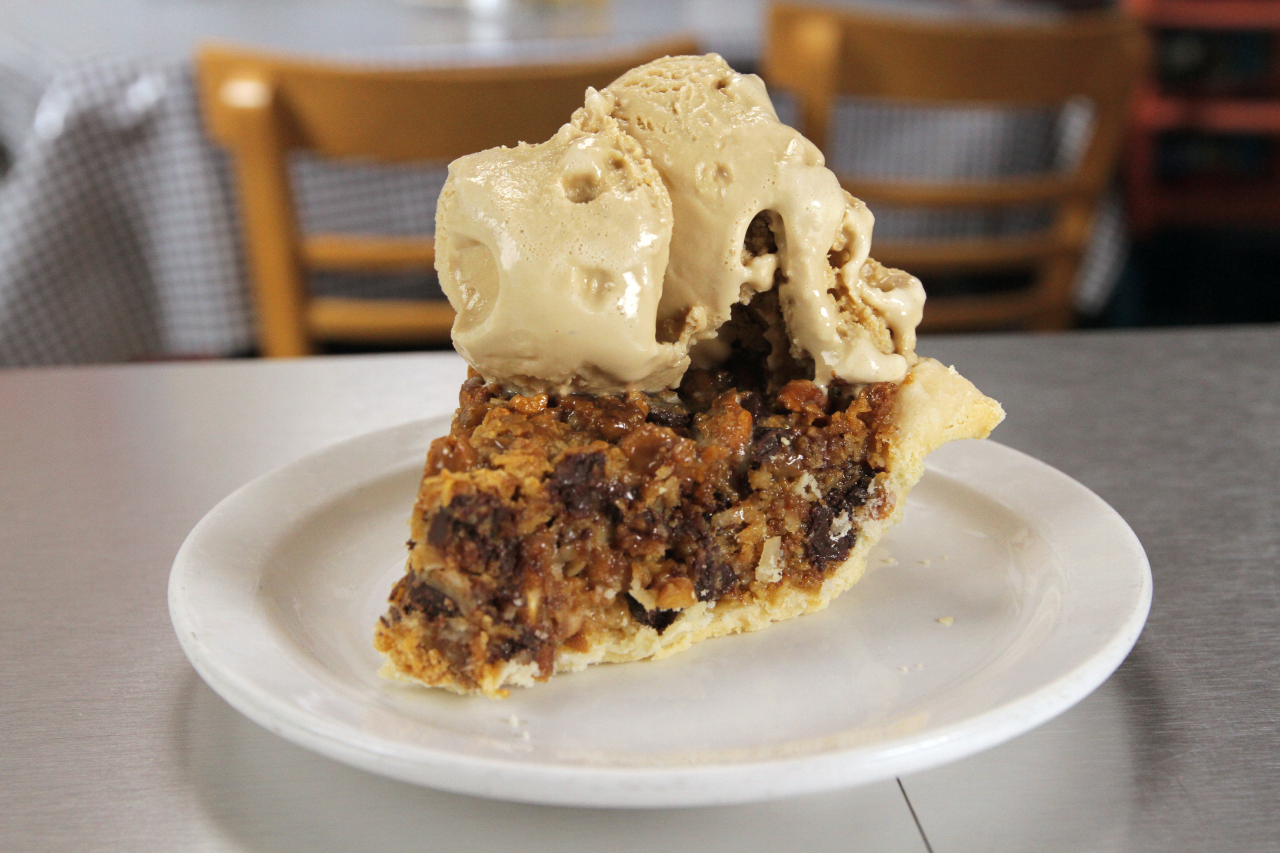 A slice of Texas trash pie with condensed milk, chocolate chips and a big scoop of ice cream on top