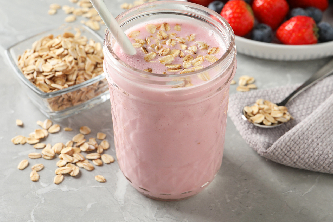 Jar of tasty berry oatmeal smoothie on grey table - stock photo