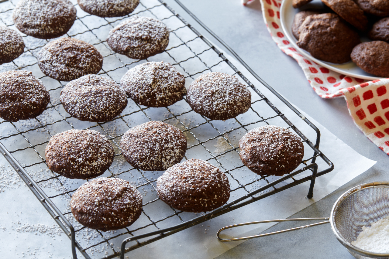 The Pioneer Woman's brownie cookies dusted with icing sugar cool on a metal tray