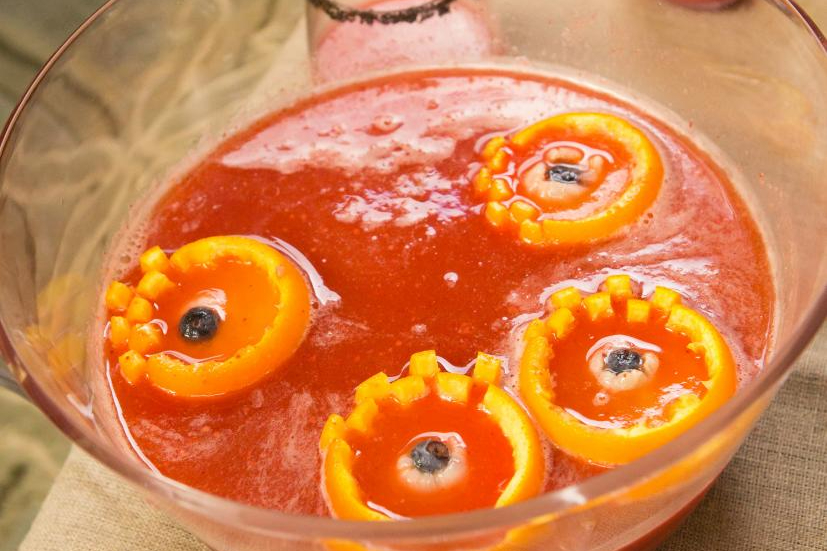Orange punch with iced hands and floating blueberry eyeballs