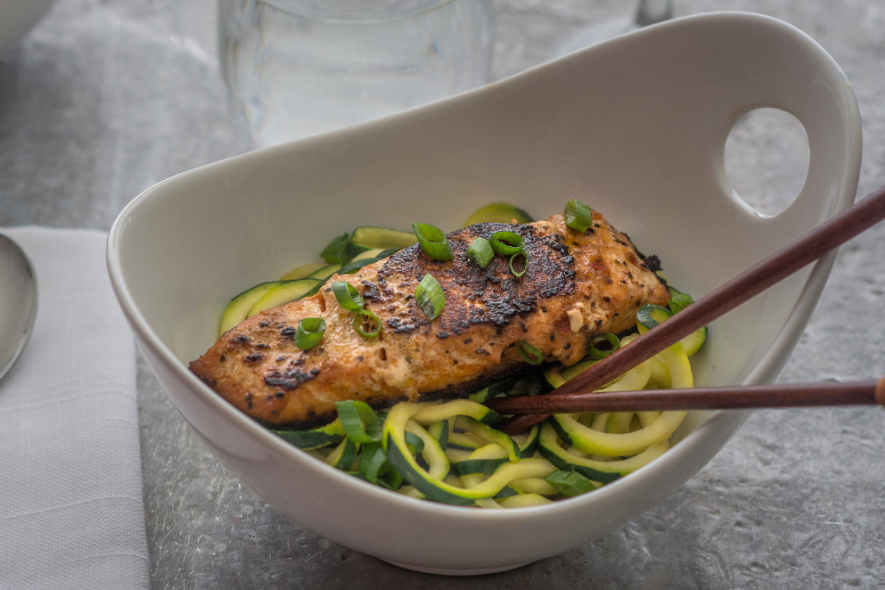 Zucchini noodles with a fillet of salmon in a deep bowl with chopsticks
