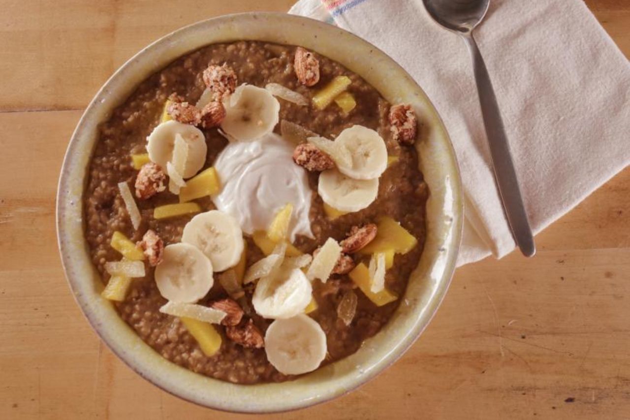 A breakfast oat bowl with bananas, buts and fruits