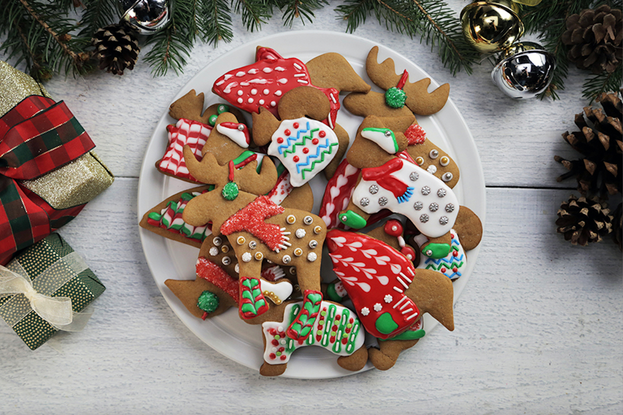 Christmas sweater shaped cookies decorated with colourful Royal icing on a plate