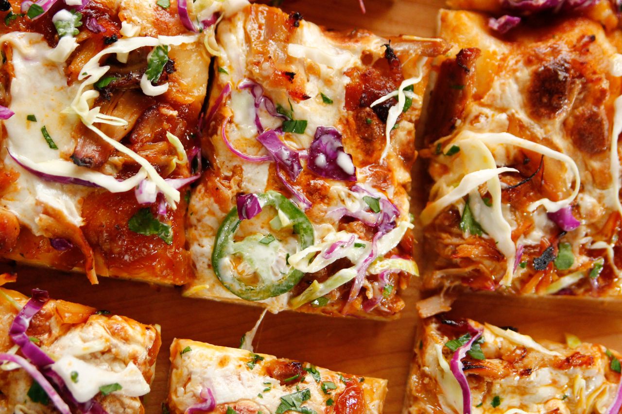 grilled pizza slices close up with peppers and cheese and red onions