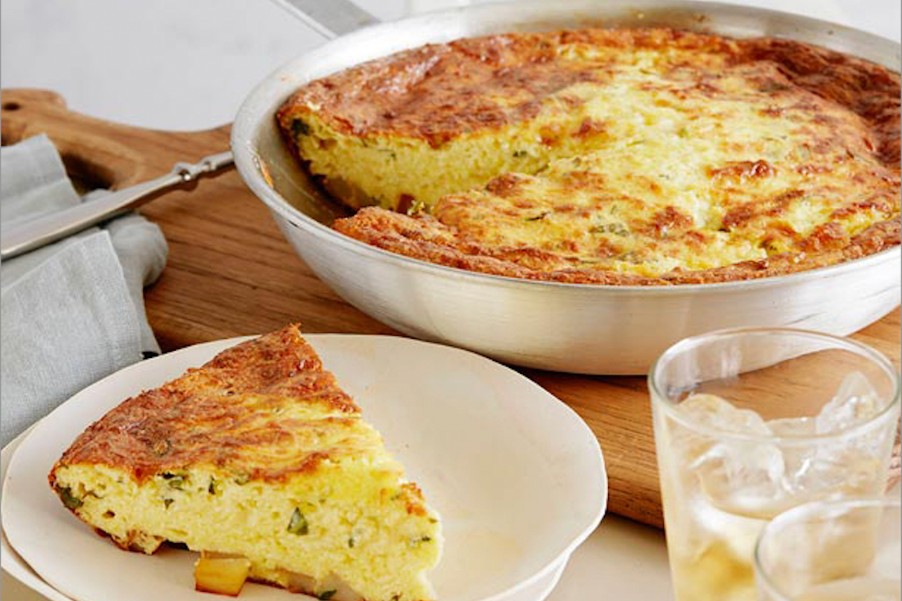 A basil and potato frittata with a sing slice served