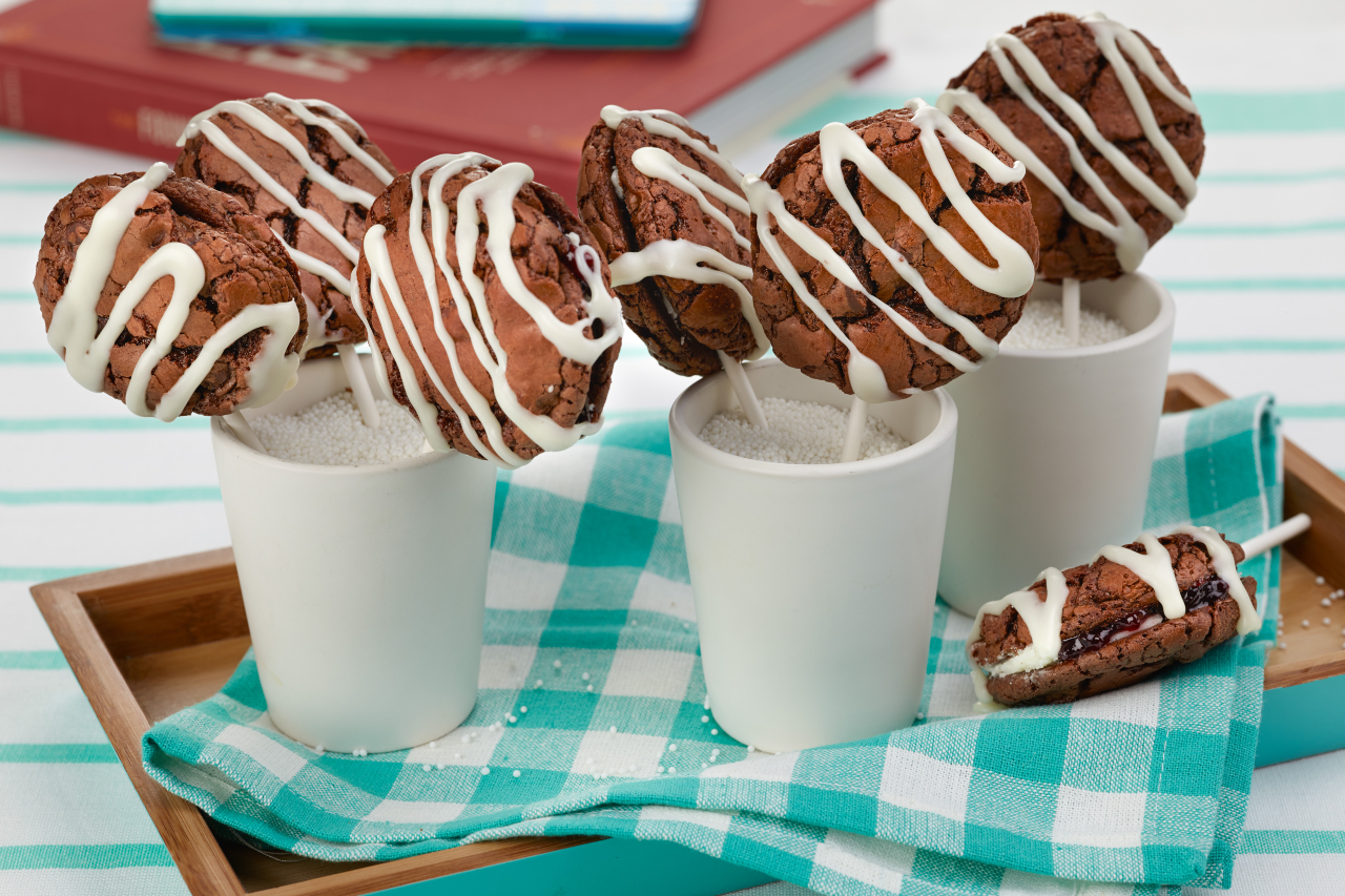Chocolate sandwich cookies on a stick in white mugs