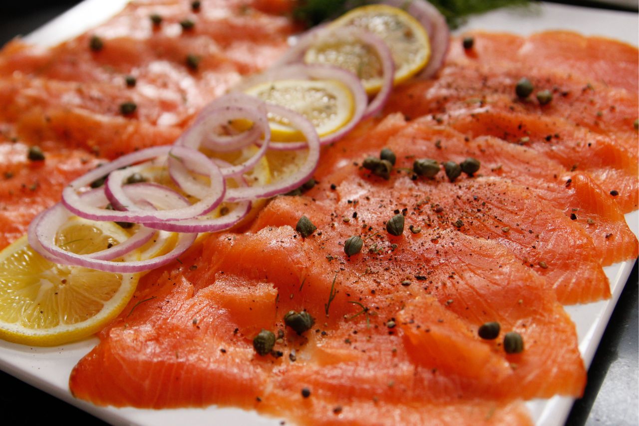 smoked salmon on a platter with capers and lemons
