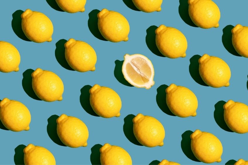 Rows of several lemons on a teal background