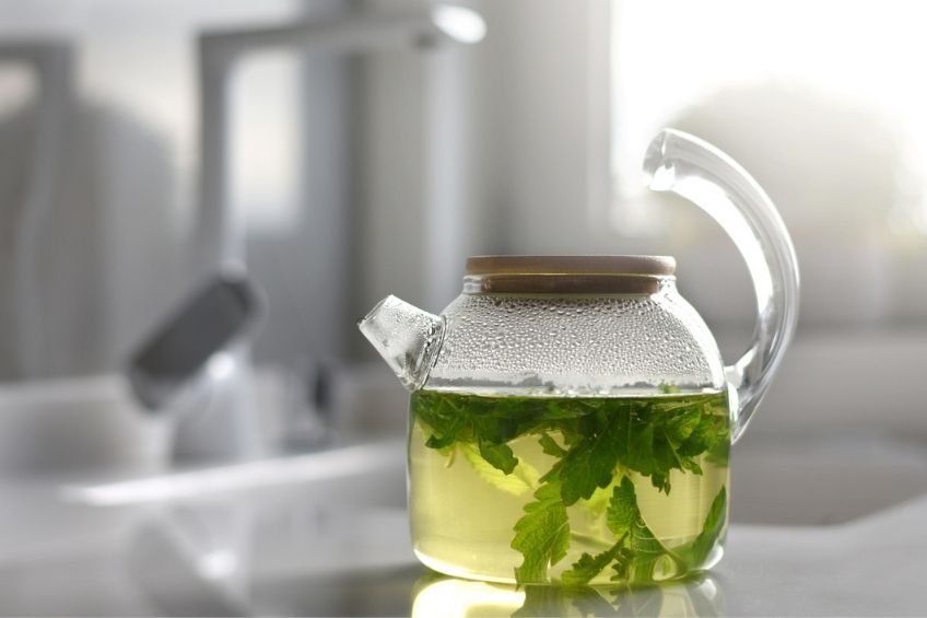 A pot of peppermint tea in a clear teapot
