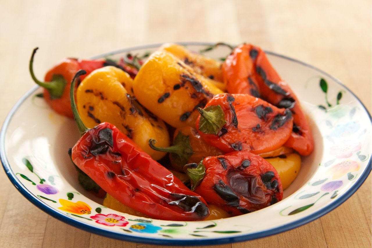 yellow and red peppers grilled in a white bowl