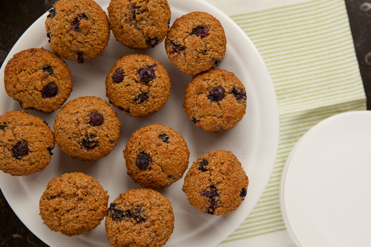 An overhead shot of bran muffins with fresh blueberries