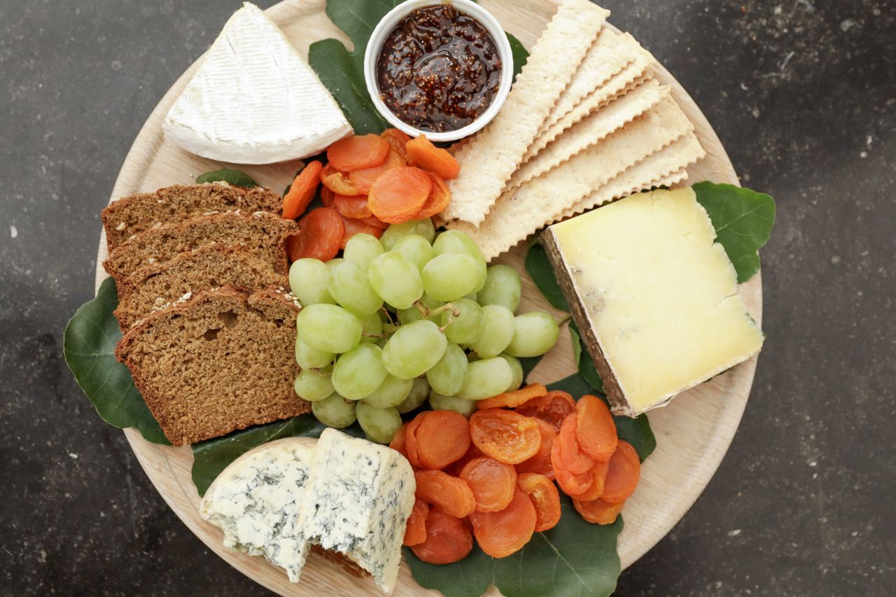 cheese and bread and fruit on a platter
