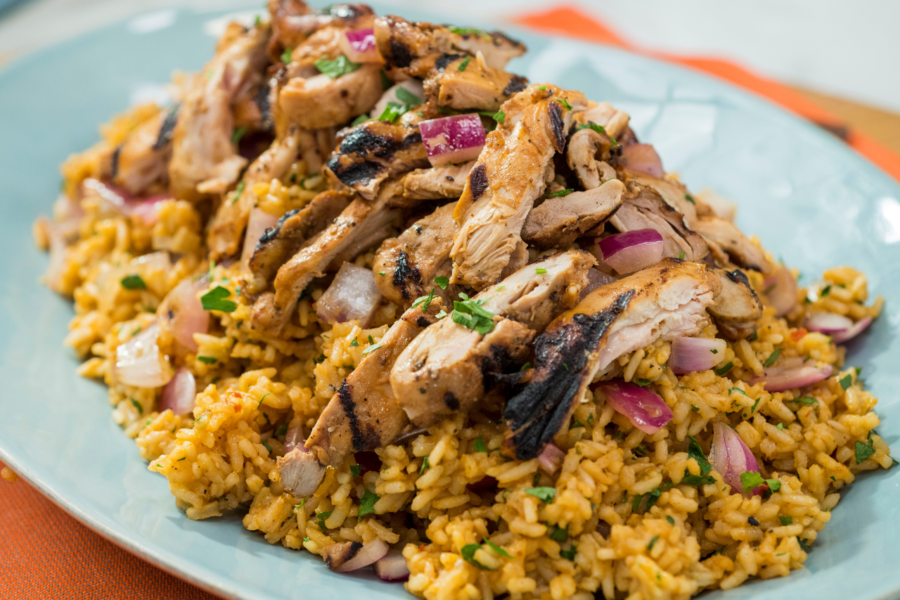 Jamaican jerk chicken and spiced rice on a blue plate