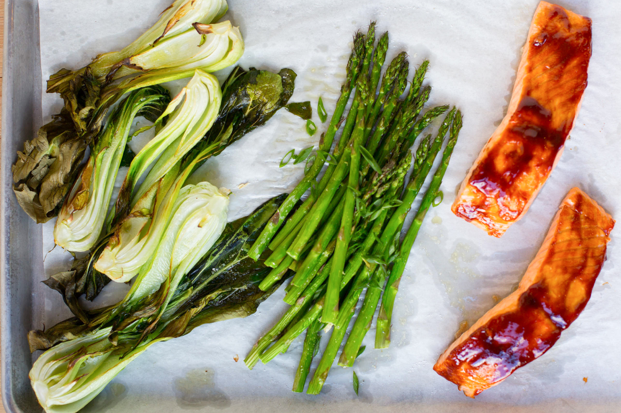 A sheet pan with bok choy, asparagus, and glazed salmon loin