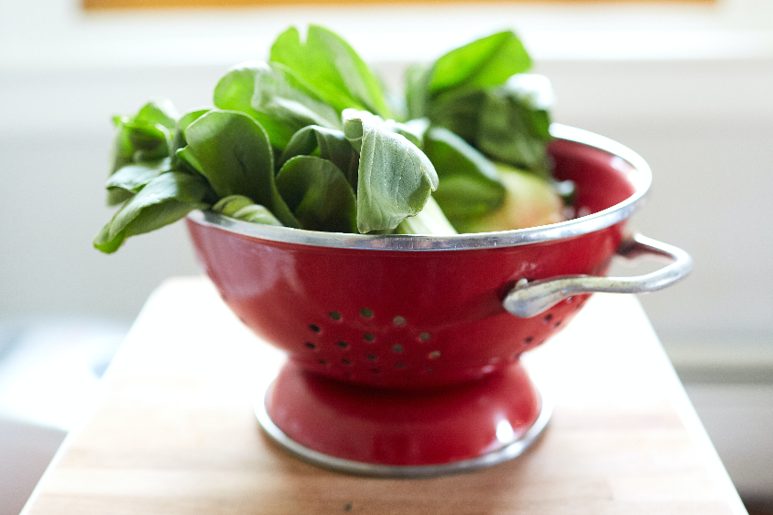 Bok choy in a red strainer