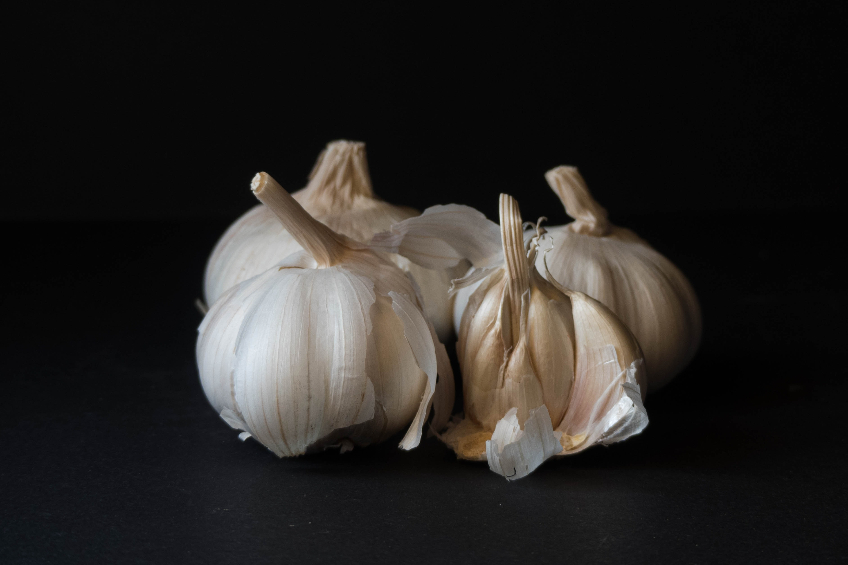 A few cloves of garlic on a black background