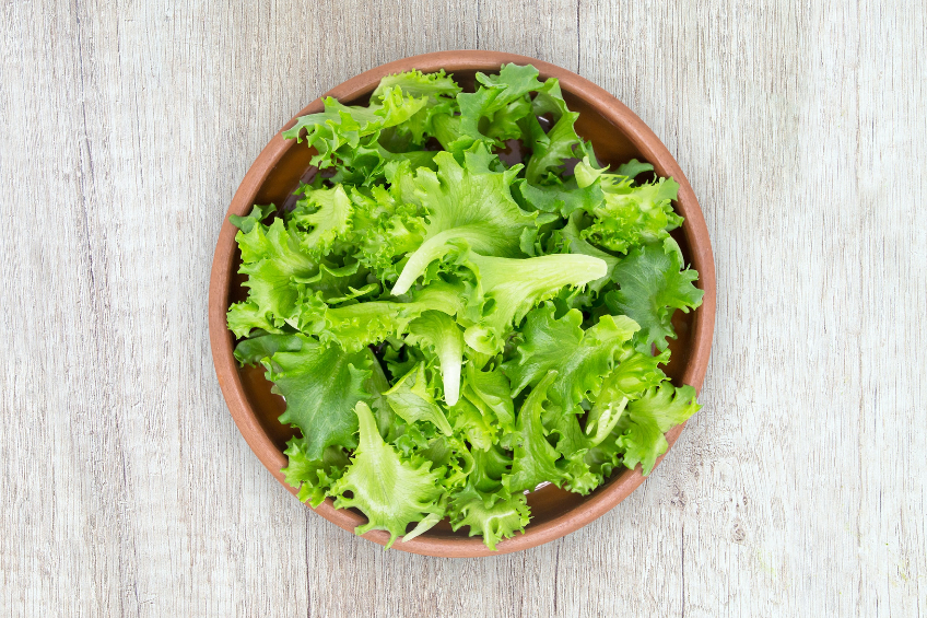 A wooden bowl of romaine lettuce