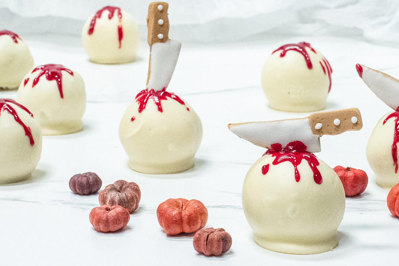 white chocolate truffles with little knives in them with fake blood