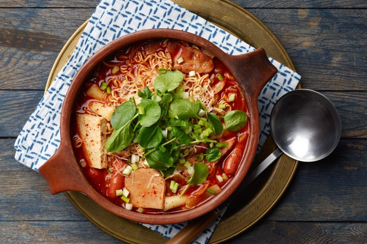 budae-jjigae in a bowl on a decorated table