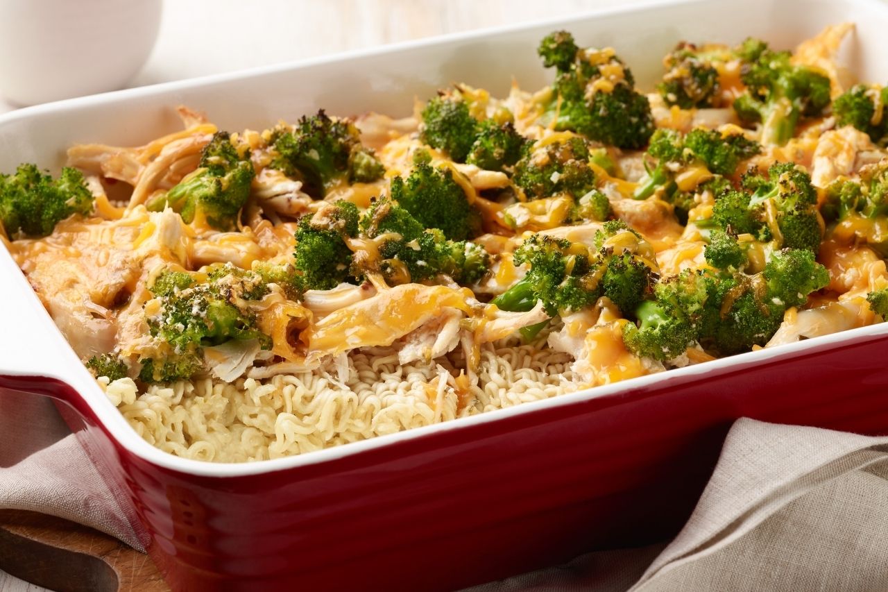 A casserole dish with ramen noodles, broccoli and cheese