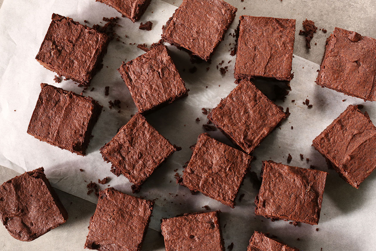 chocolate brownies on a sheet pan cut into squares
