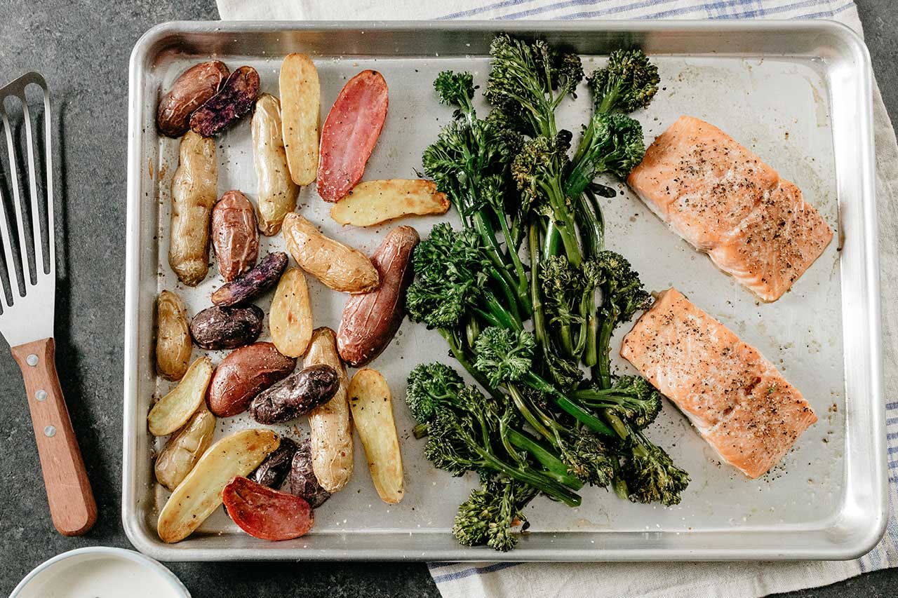 Overtop view of sheet pan with salmon, potatoes and broccoli