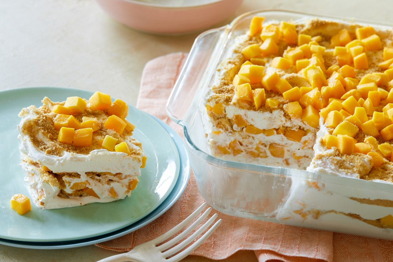 A glass tray with mango float and a slice of it on a blue plate