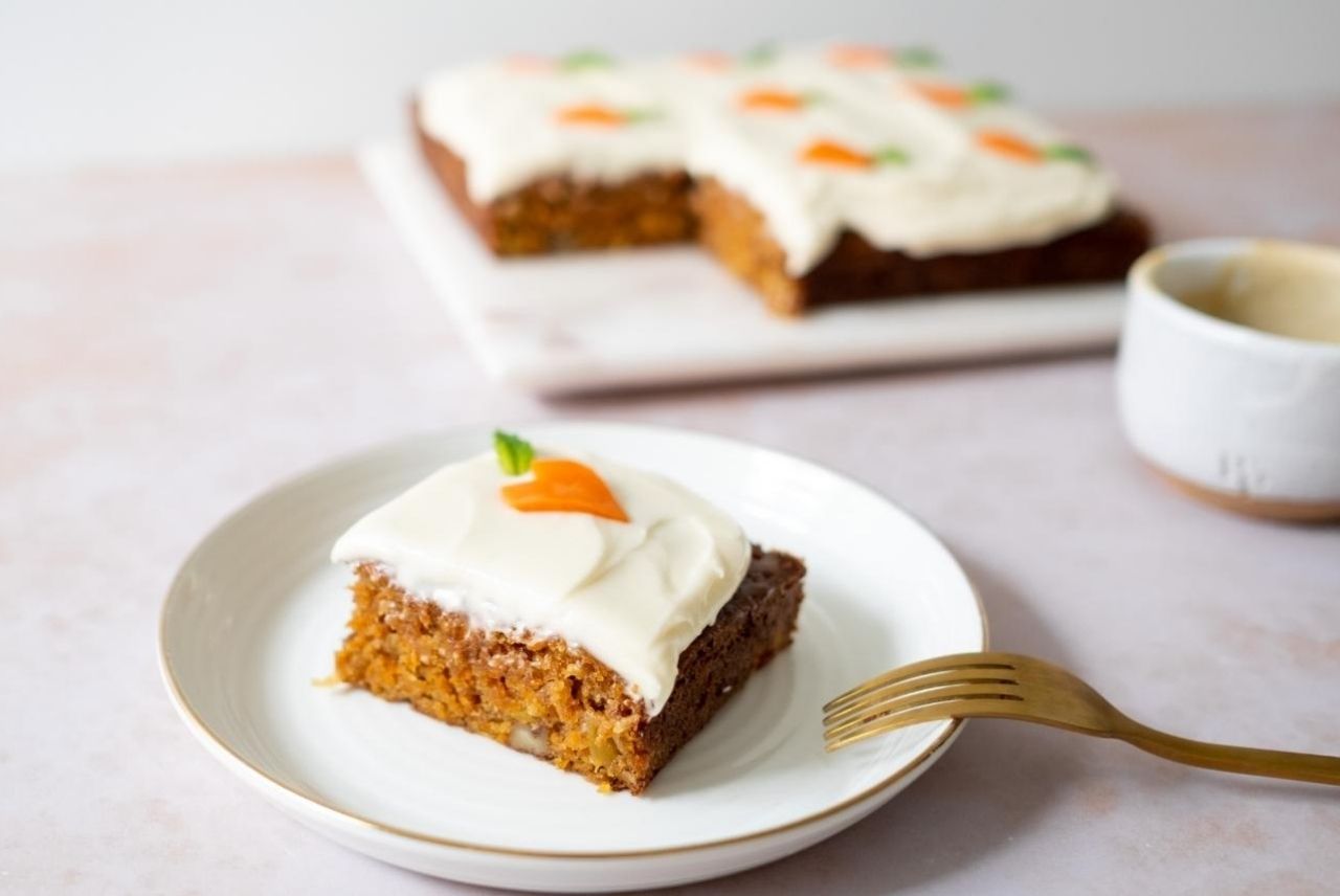 A close up of a slice of carrot cake on a white plate