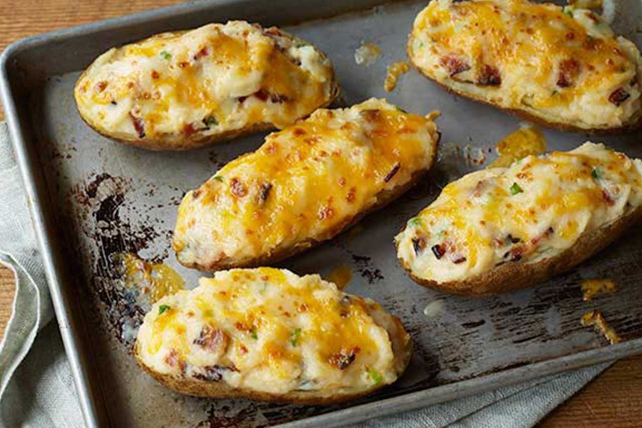 Baked potatoes on a sheet pan with melted cheese