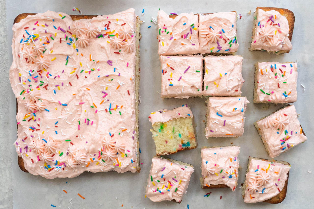confetti sheet cake with pastel pink icing and rainbow sprinkles