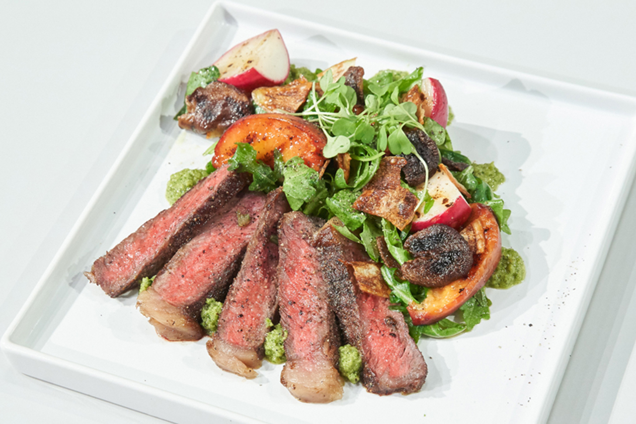White plate filled with steak and salad