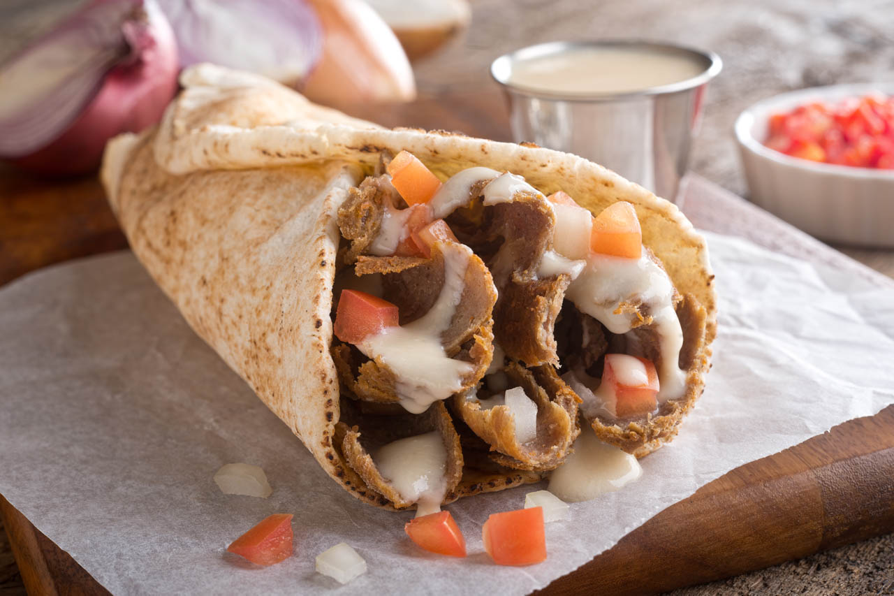 A Halifax donair with garlic sauce and fresh chopped vegetables