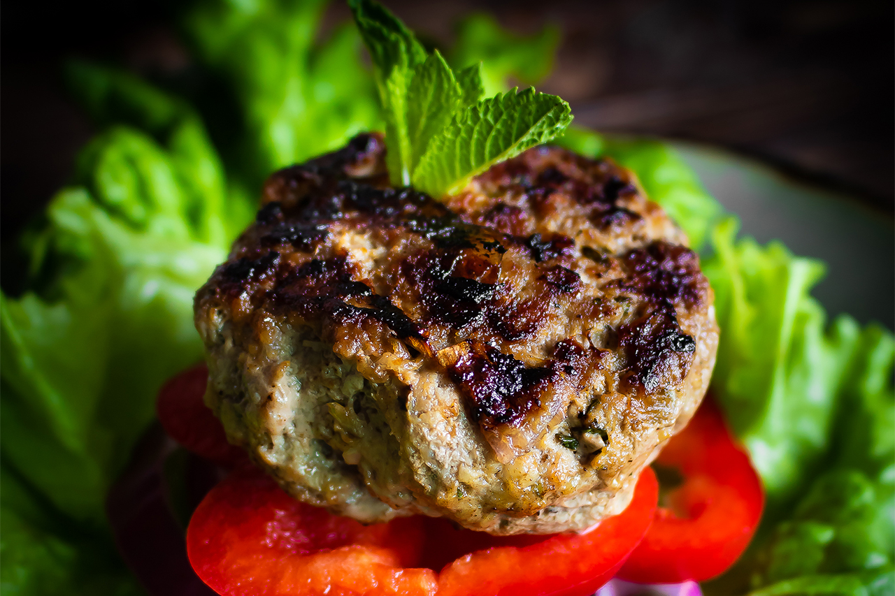Close-up of lamb burger on a bed of lettuce