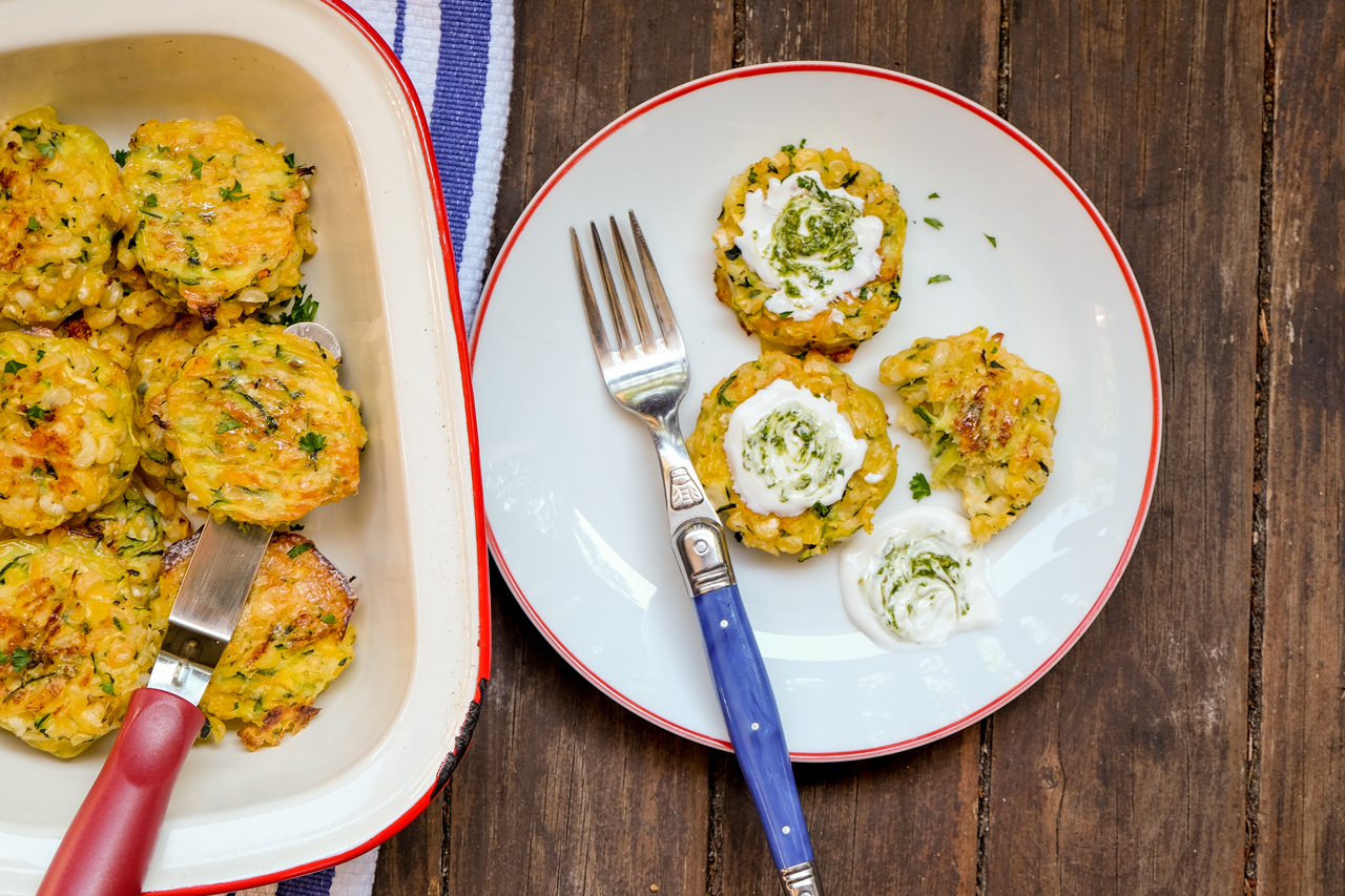 Golden fried zucchini and corn fritters topped with sour cream and sprinkled with chives