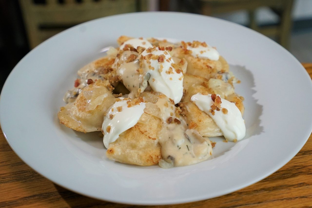 Overhead shot of homestyle pierogies with sour cream