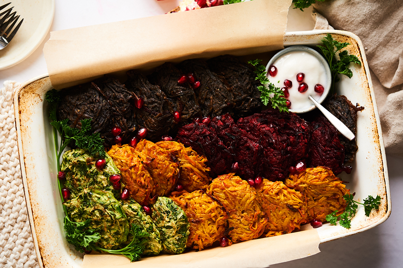 plate of rainbow coloured latkes stacked with decorations