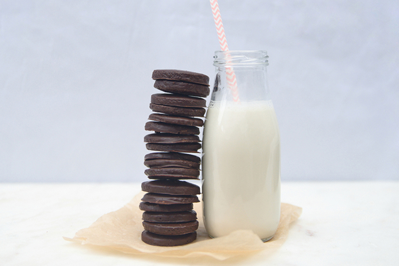vegan thin mints stacked vertically against a milk bottle