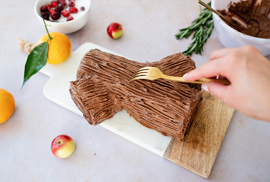 Yule log icing being applied and given a bark-like pattern