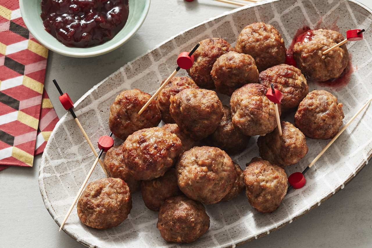 Air fryer Swedish meatballs on a white tray with lingonberry jam on the side