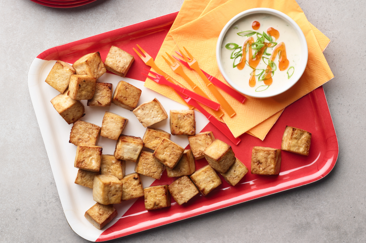 Crispy air fryer tofu on a serving tray with a bowl of dipping sauce