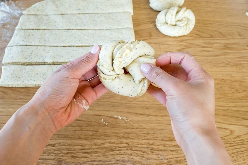 Lemon poppy seed buns being formed by hand