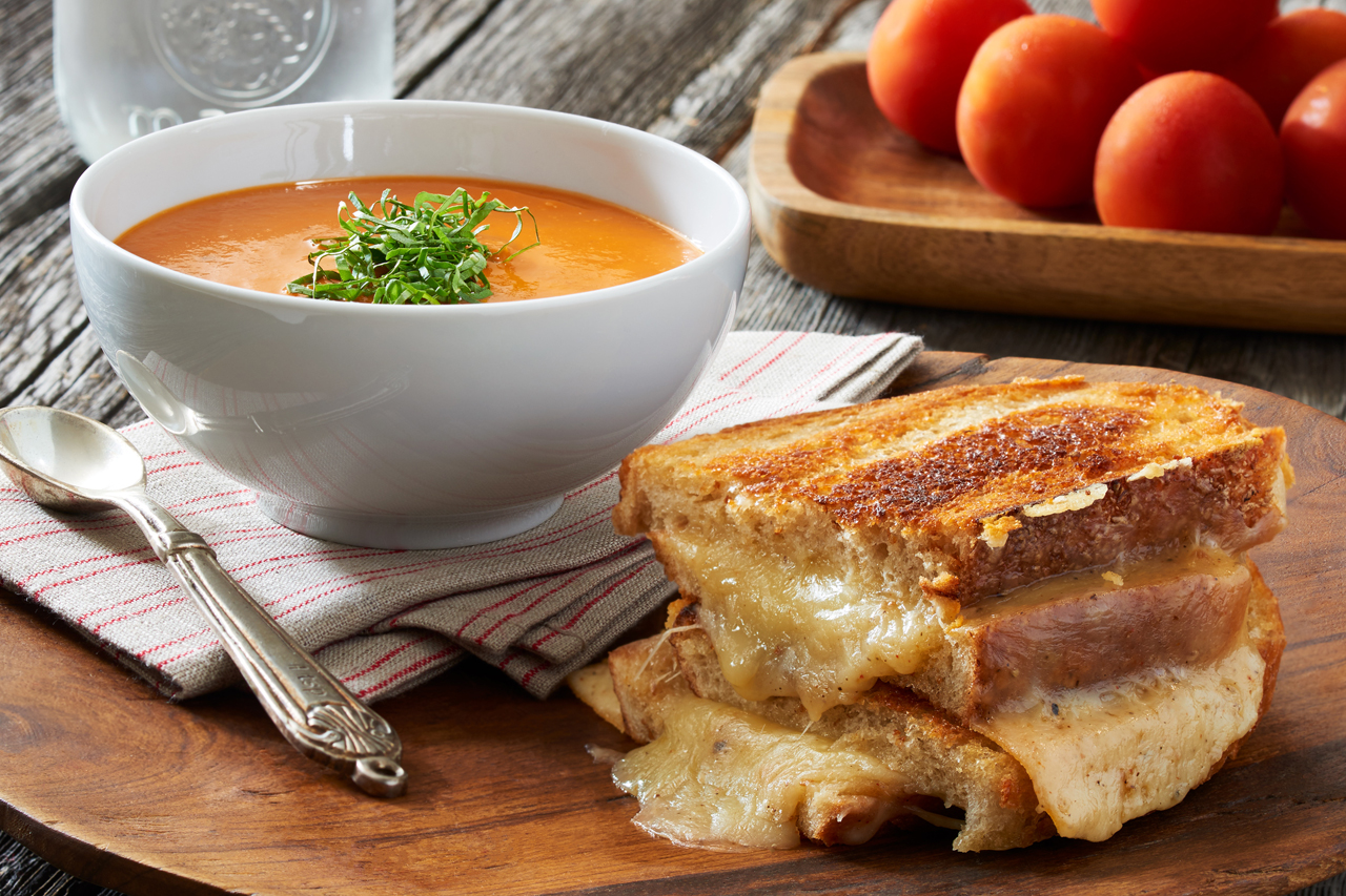 Grilled cheese sandwich with a bowl of tomato soup on the side